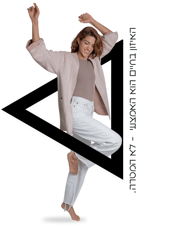 אישה מחייכת מאזנת על רגל אחת עם ידיים מורמות, לבושה ז׳קט בהיר ומכנס לבן; משולש שחור ברקע וטקסט אנכי - המחשת קלילות ואיזון.